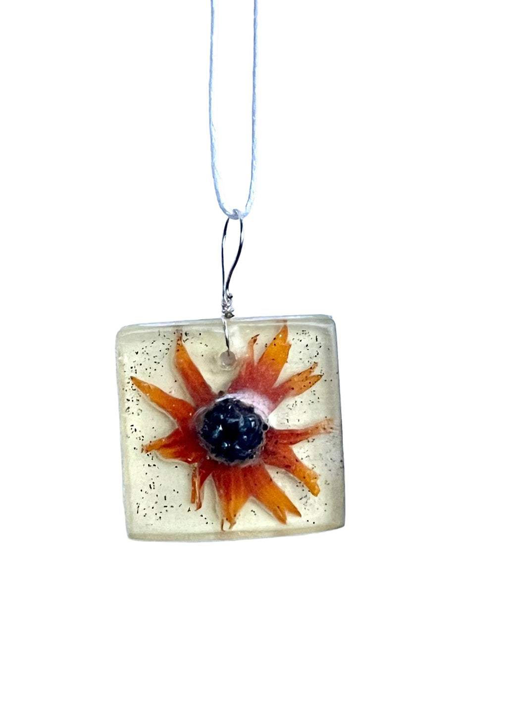Square pendant with a black eyed Susan on a white background