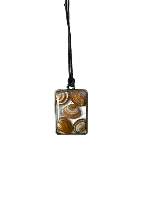 Necklace with a rectangular pendant featuring shell designs on a white background