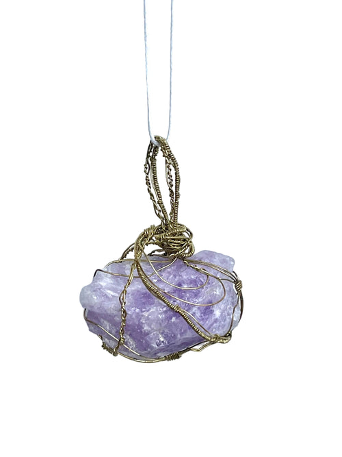 Purple crystal pendant with gold wire wrapping on a white background