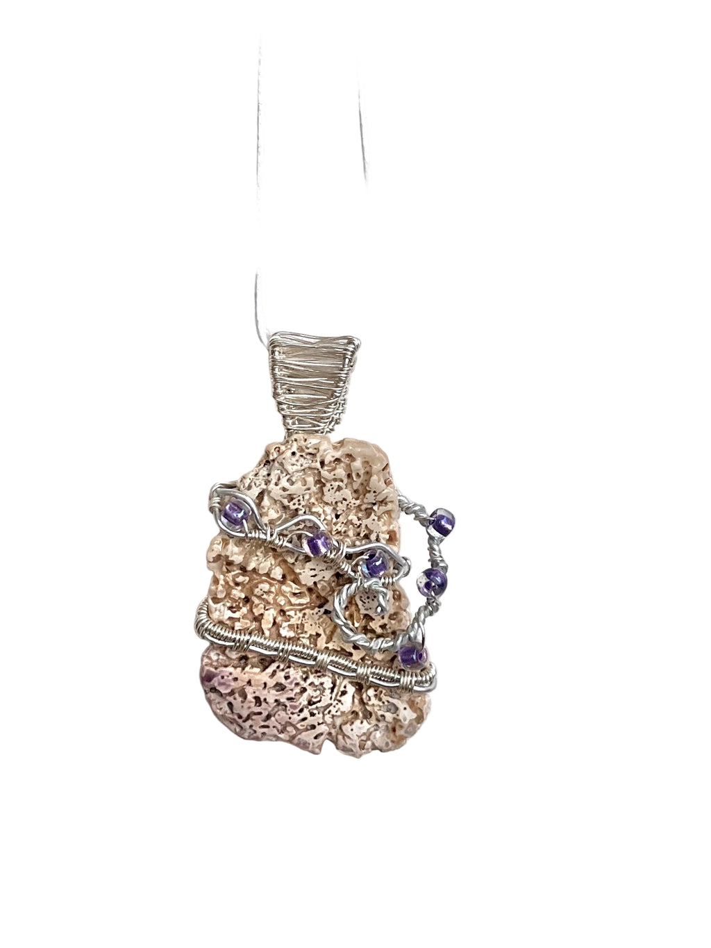 Pendant with natural shelland purple beads on a white background
