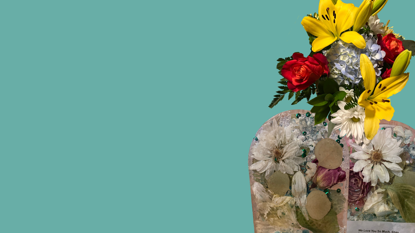A decorative floral arrangement on the right side of a teal background, featuring yellow lilies, red roses, white daisies, and other pressed flowers in resin bookends.