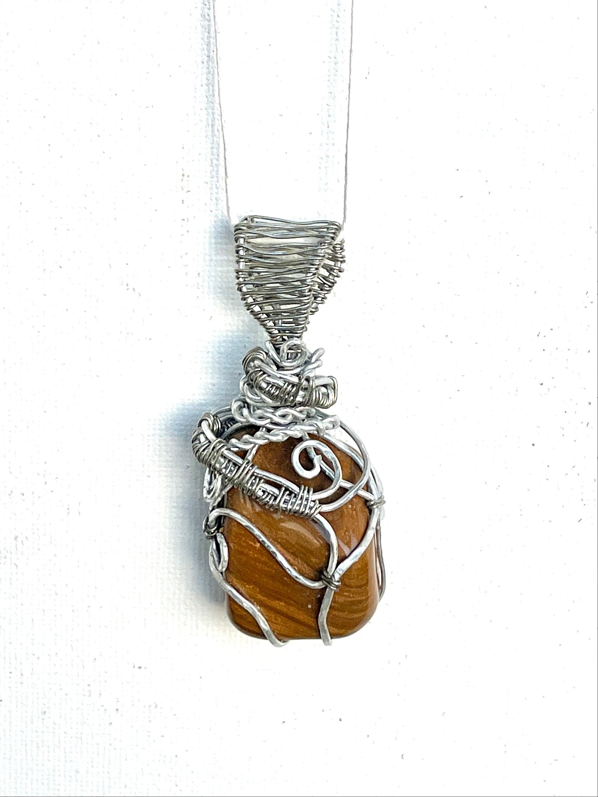 Pendant necklace with yellow jasper and silver wire wrapping on a white background
