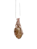Necklace with a pendant featuring a natural stone wrapped in wire on a white background