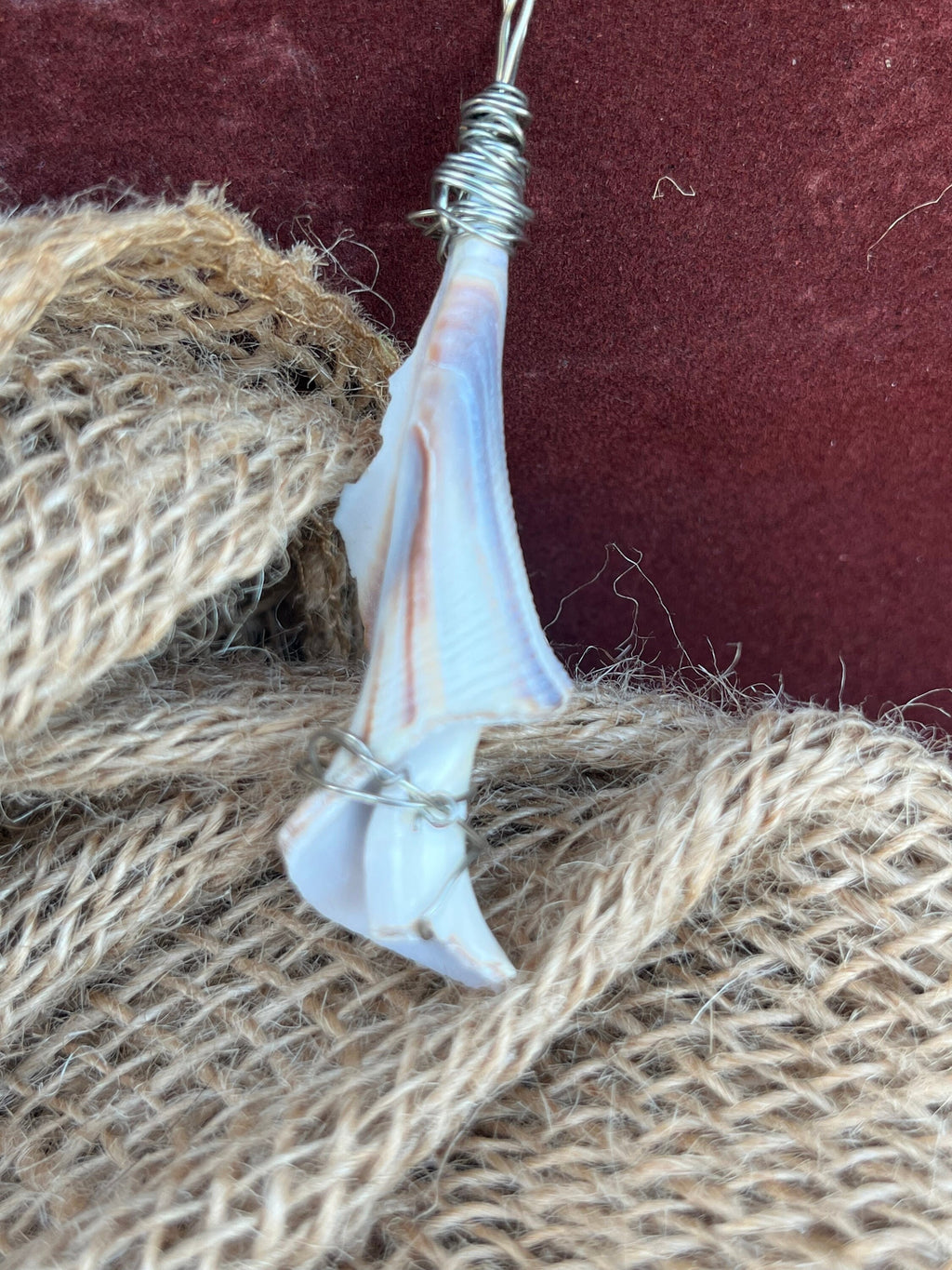 Shell ornament on a piece of burlap with a red background