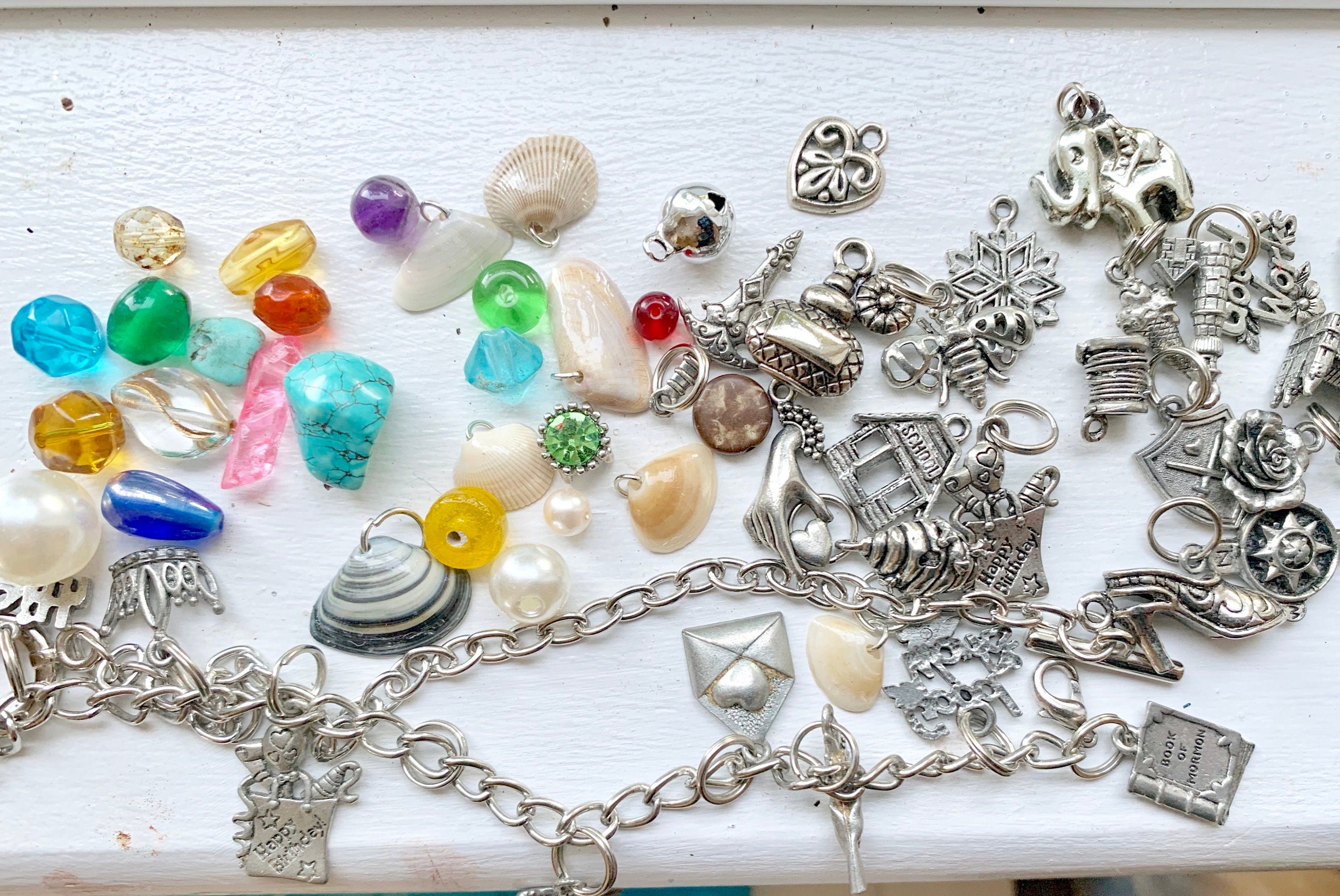Collection of various charms and beads on a white surface