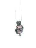 Silver and coral pendant on a white cord against a white background
