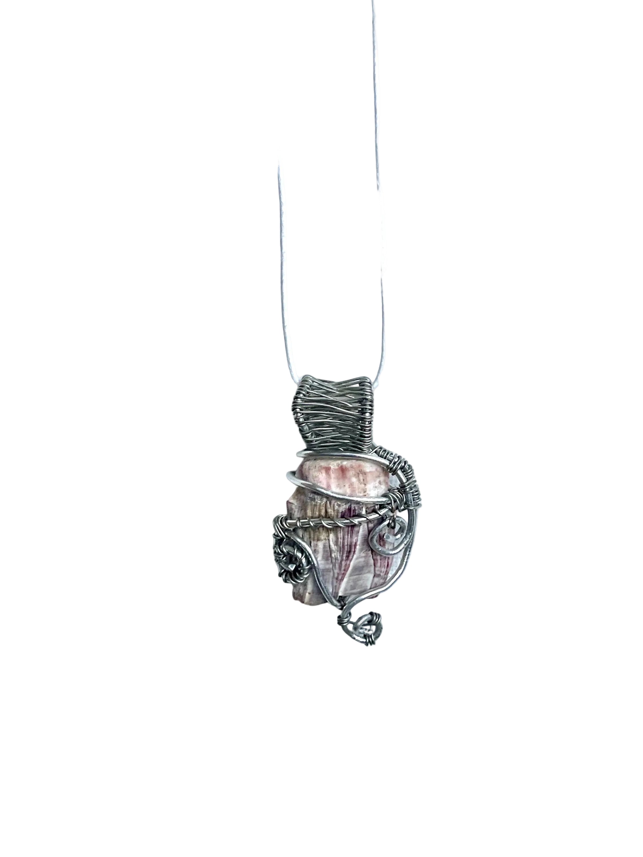 Silver and coral pendant on a white cord against a white background