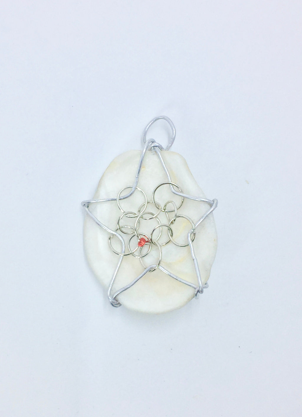 bead on wire wrapped star on a white shell