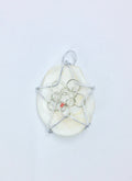 bead on wire wrapped star on a white shell
