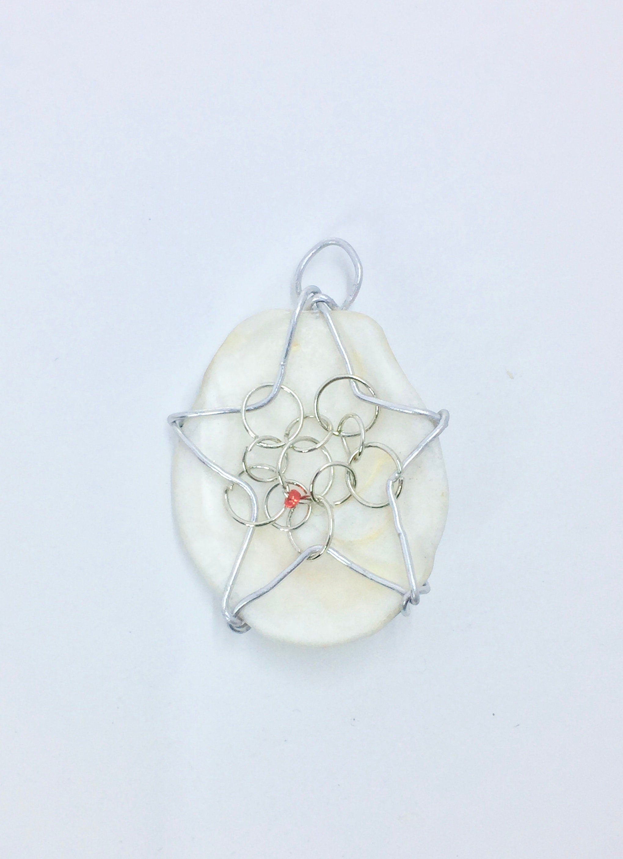 bead on wire wrapped star on a white shell