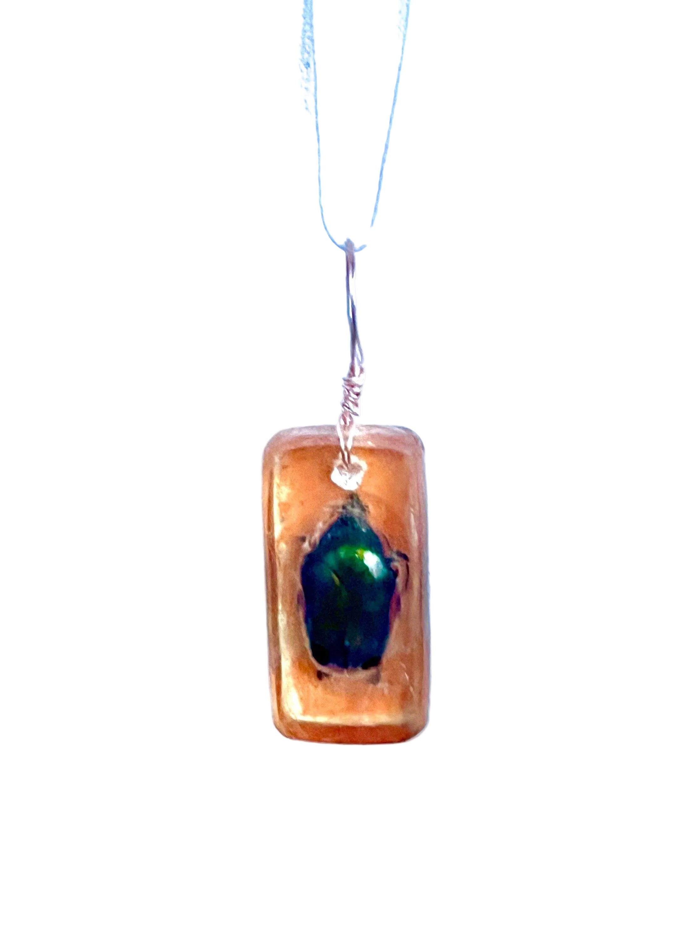 Necklace with a rectangular pendant featuring a green insect on a white background