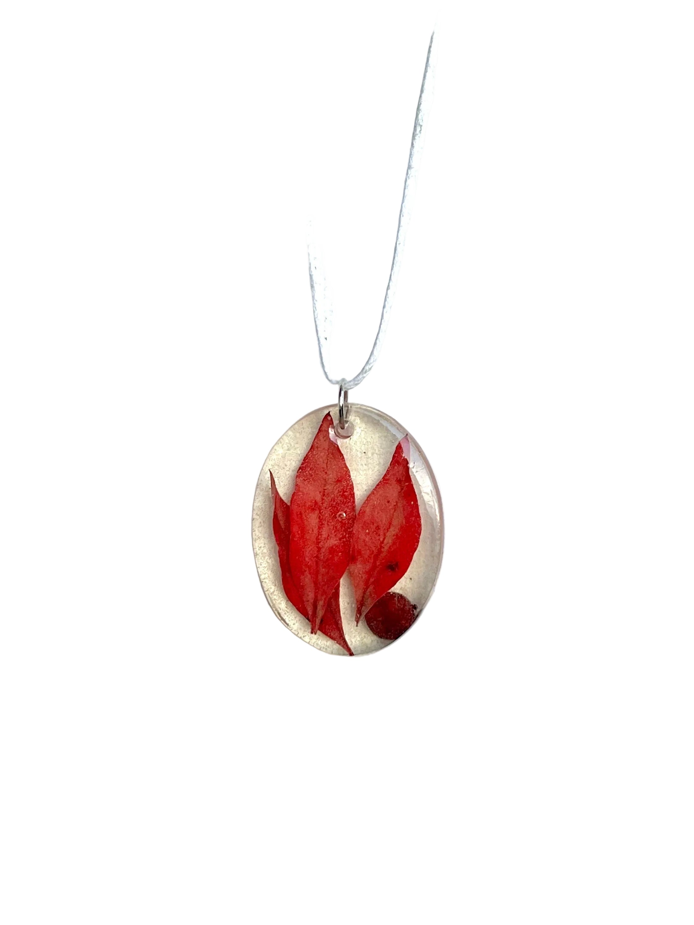 Necklace with a red leaf pendant on a white background