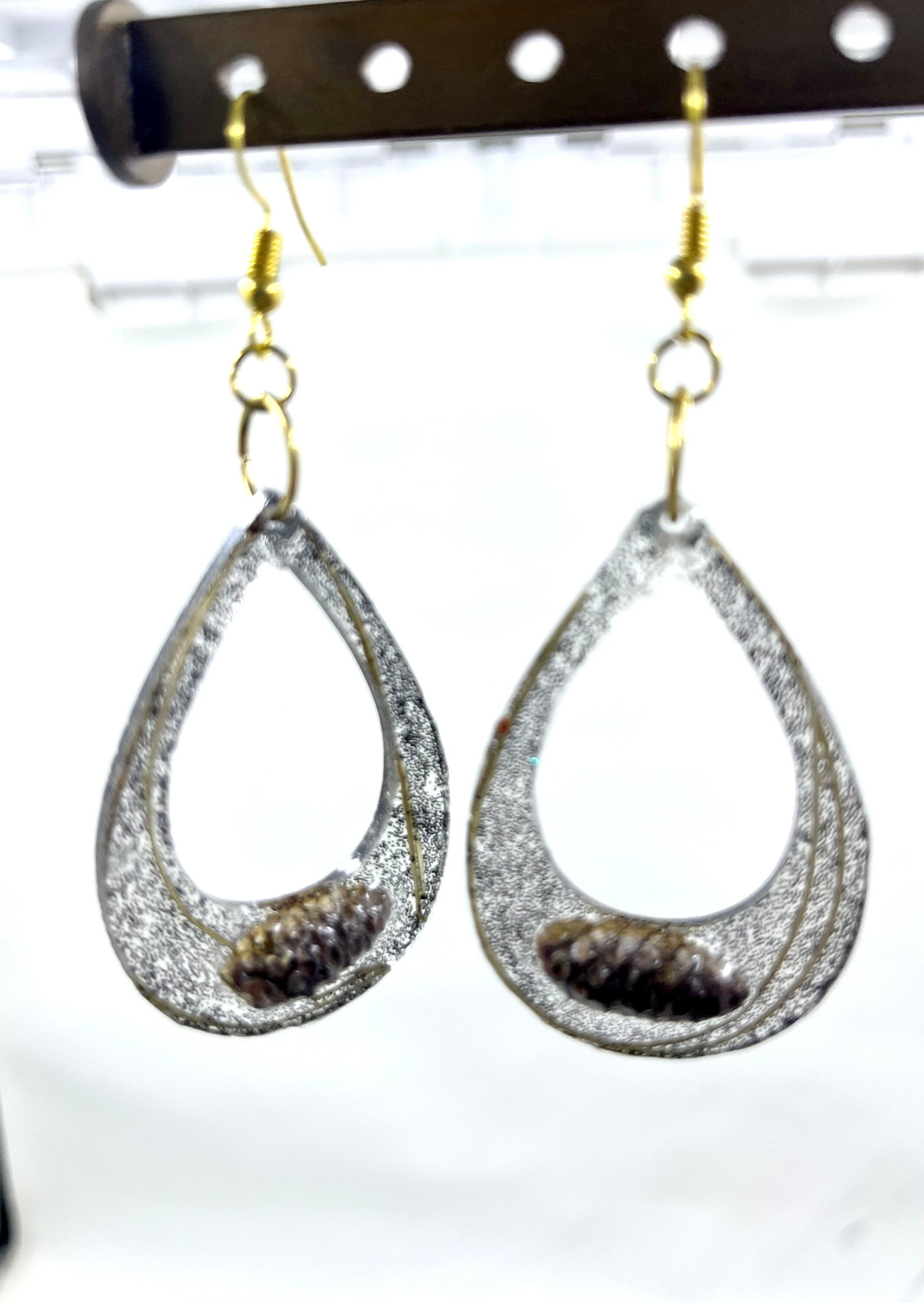 Teardrop-shaped earrings with glittery finish on a white background