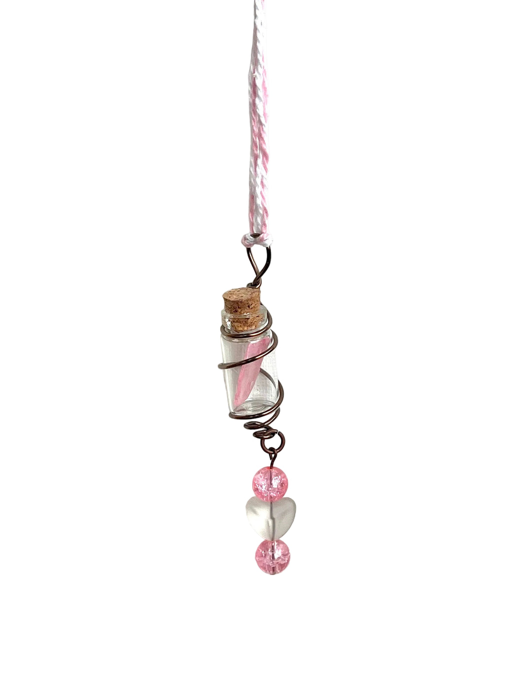 Decorative hanging pendant with pink beads and a small bottle on a white background