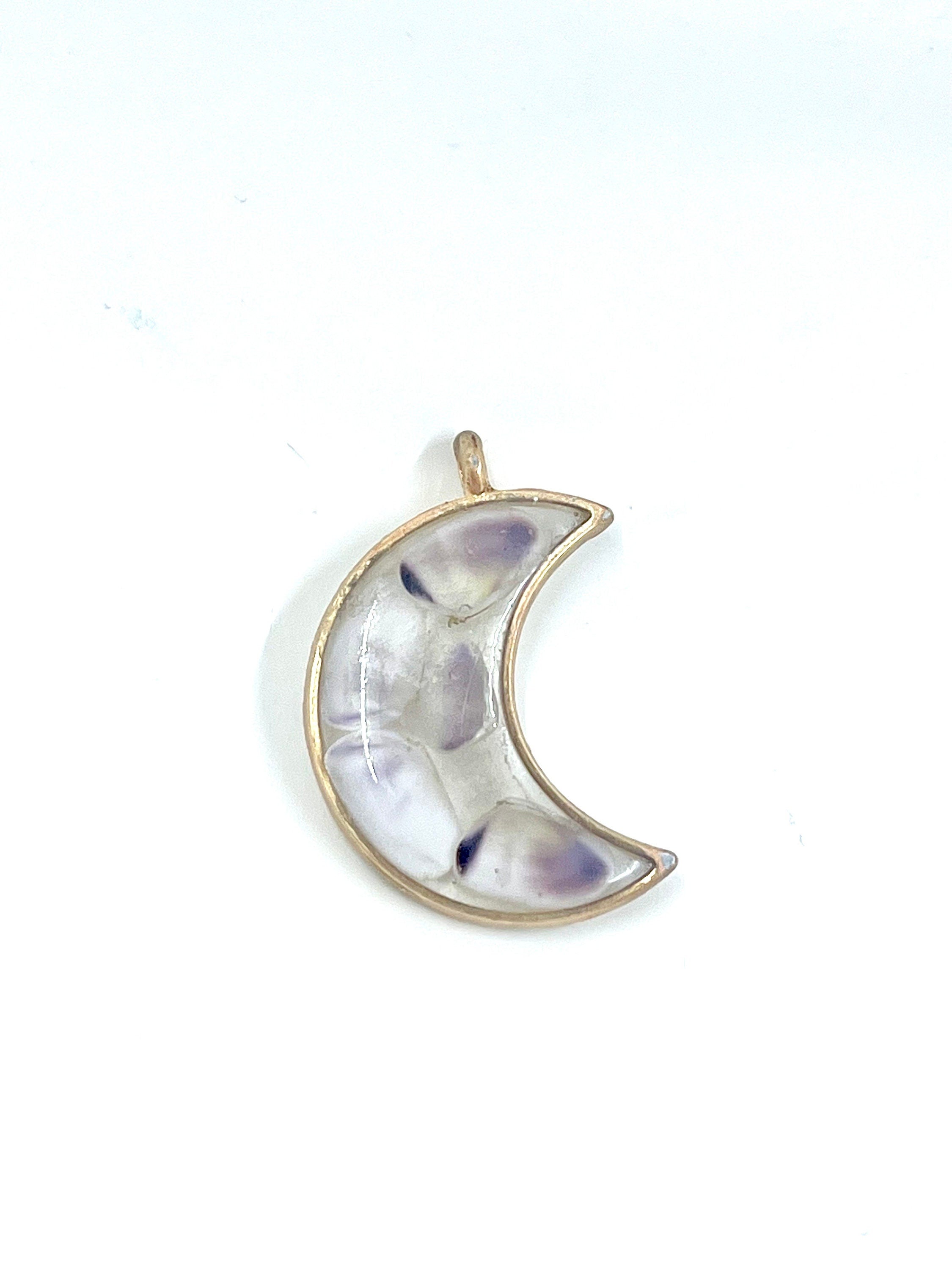 Crescent moon-shaped pendant with a gold outline on a white background