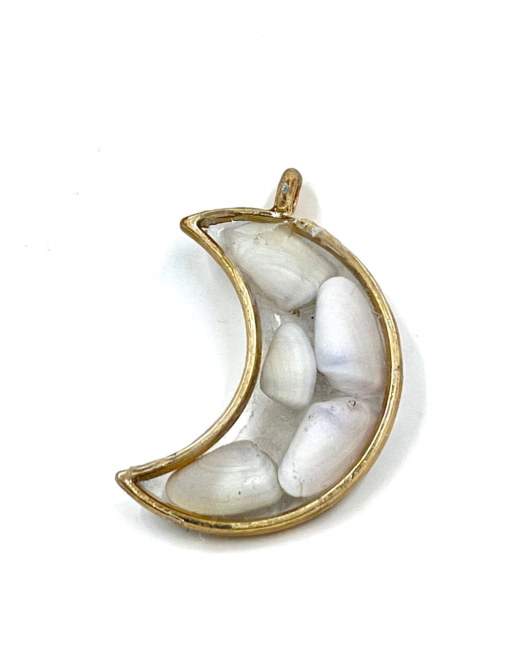 Gold crescent moon-shaped pendant with white shells on a white background
