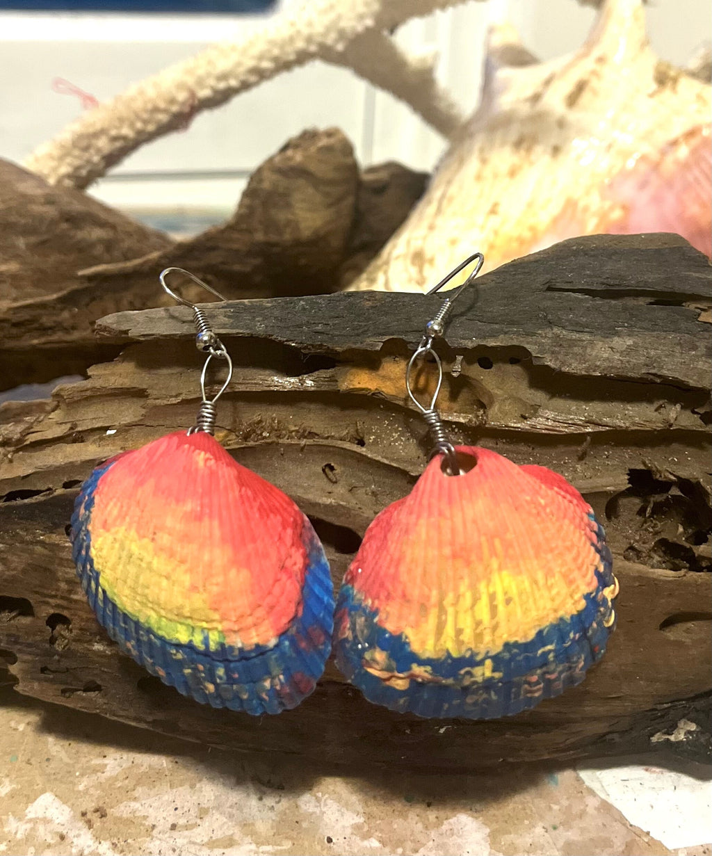 Colorful shell-shaped earrings on a wooden surface 
