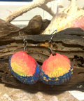 Colorful shell-shaped earrings on a wooden surface 