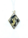 Diamond-shaped pendant with tiger butterfly wings on a white background