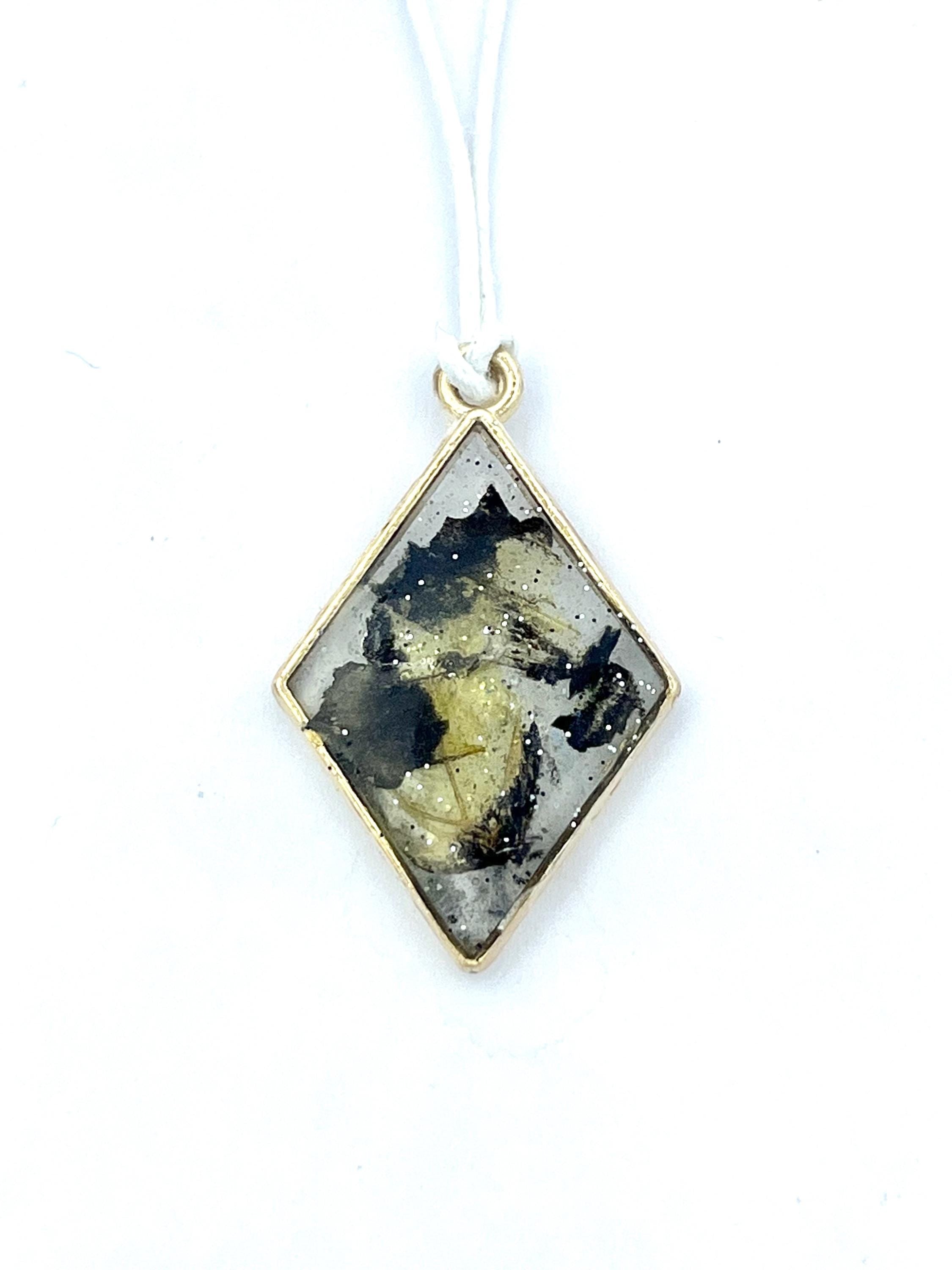 Diamond-shaped pendant with tiger butterfly wings on a white background