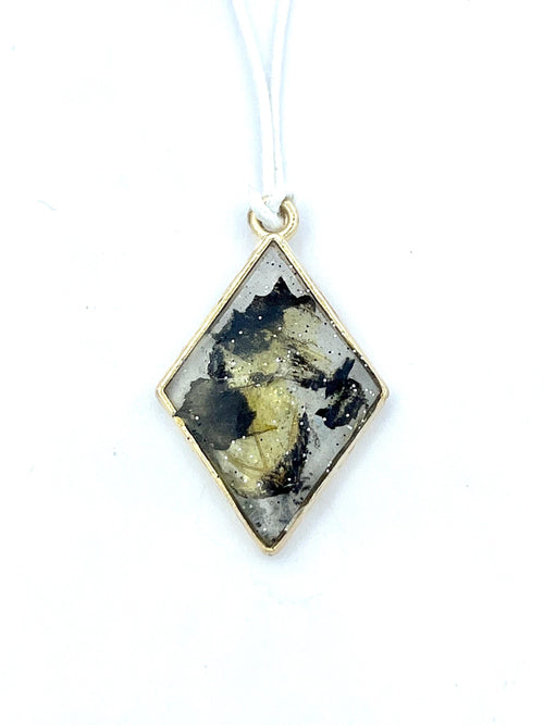Diamond-shaped pendant with tiger butterfly wings on a white background