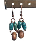 Pair of earrings with turquoise and wooden beads on a white background.
