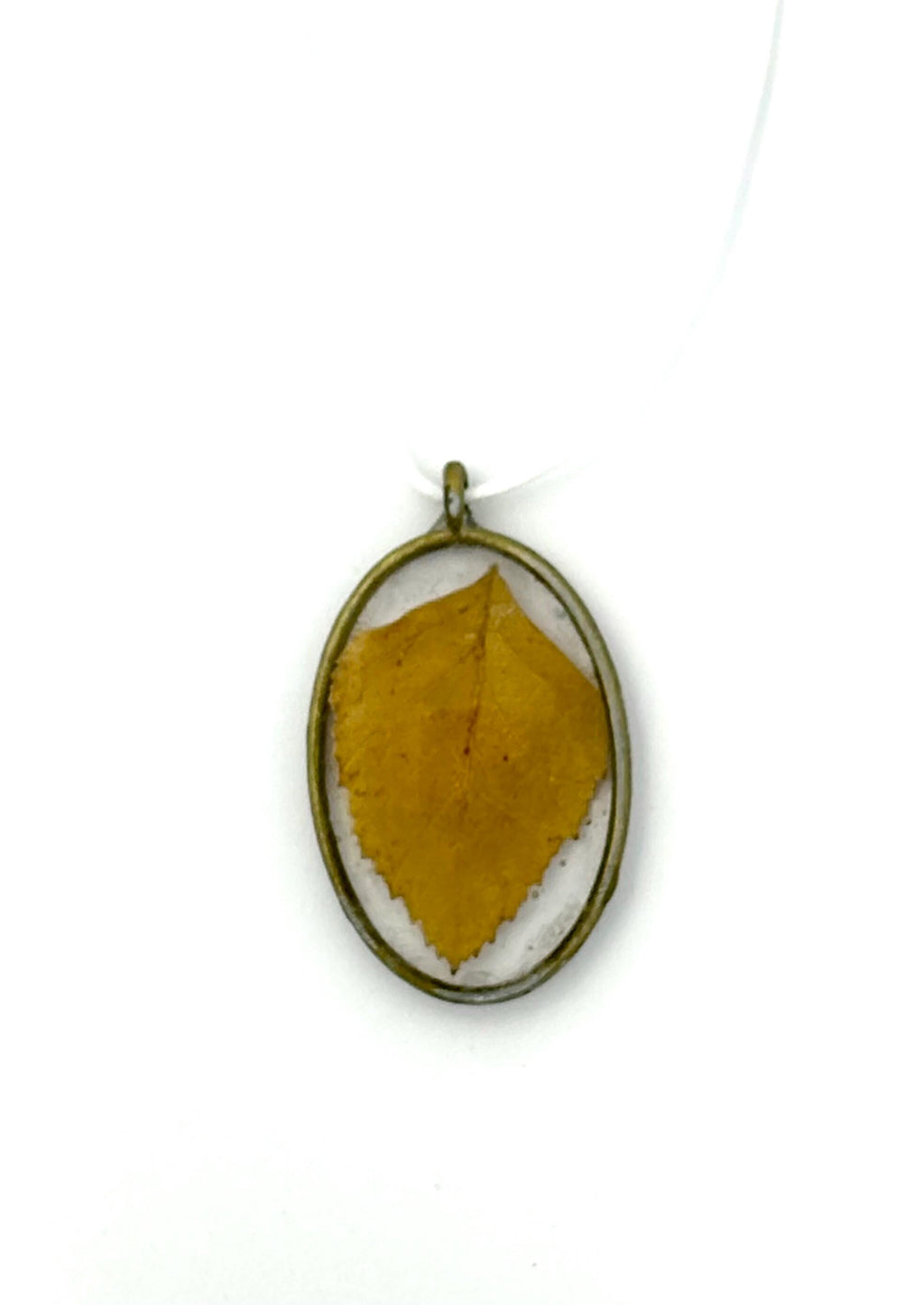 Gold pendant with a yellow leaf on a white background