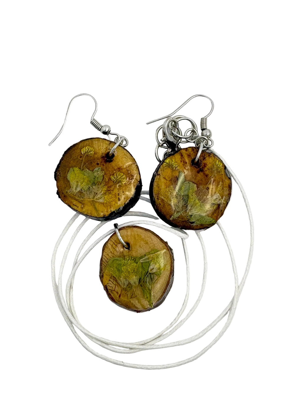 Wooden earrings and necklace with leaf patterns on a white background